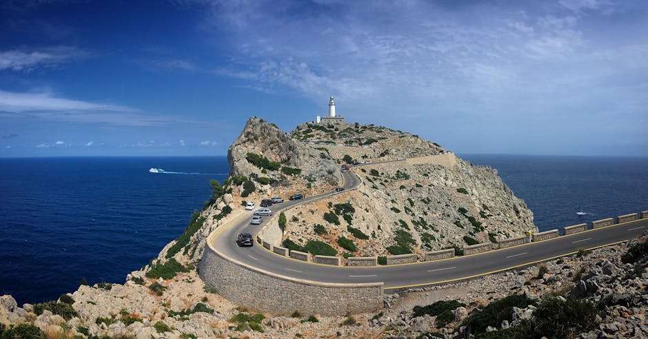 Panoramic view of Cap de Formentor lighthouse with winding coastal road and clear blue sea
