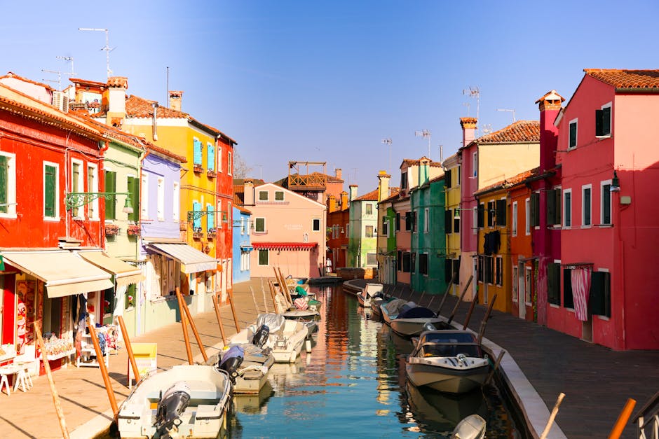 A picturesque view of Burano's colorful houses lining a serene canal, showcasing the vibrant charm of Italian architecture