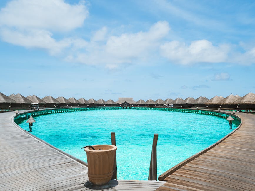 Scenic view of overwater bungalows and turquoise lagoon under clear skies, perfect for a tropical getaway