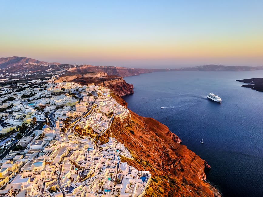 Stunning aerial shot of Santorini coast at sunset with a cruise ship in the Aegean Sea