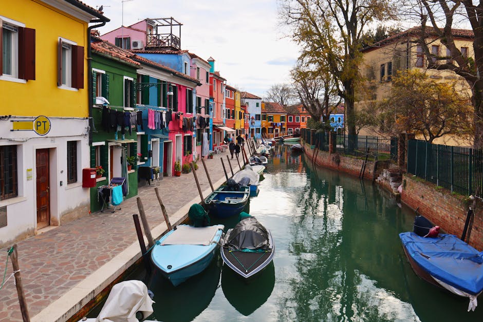 Vibrant canal scene in Burano, Venice, featuring colorful houses and moored boats